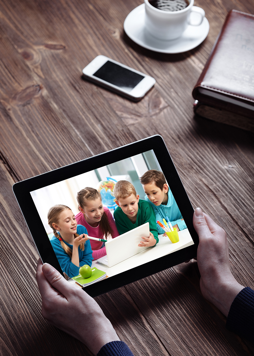 Teacher Holding a Tablet Showing an Image of the FB Group